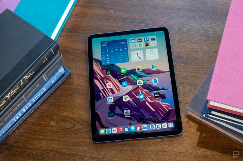 An iPad on a desk surrounded by books. 
