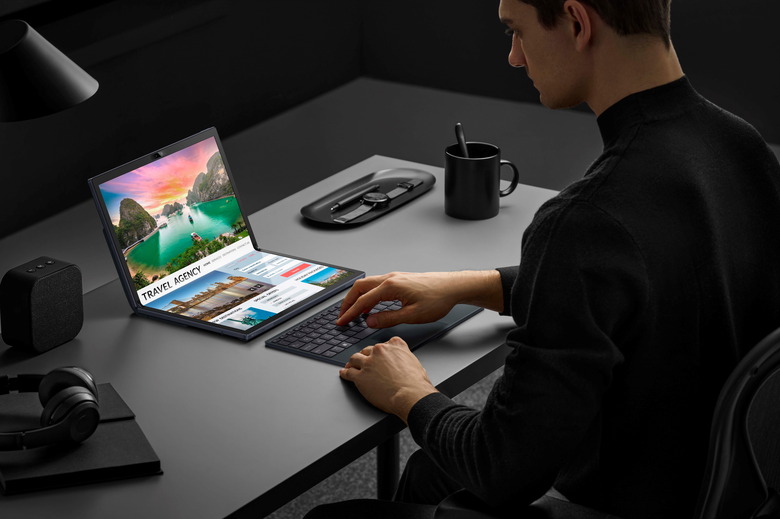 A person has their hands on a Bluetooth keyboard while they look at a ASUS Zenbook 17 Fold OLED.