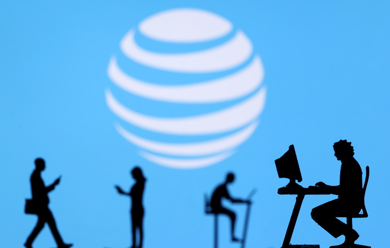 Small toy figures with laptops and smartphones are seen in front of displayed AT&T logo, in this illustration taken December 5, 2021. REUTERS/Dado Ruvic/Illustration