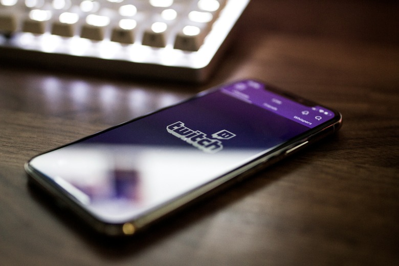 A phone lying on a desk with the Twitch app open.