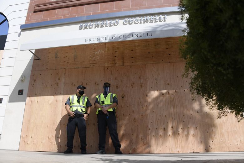 BEVERLY HILLS, CA - NOVEMBER 03: Beverly Hills police traffic officers stand guard in front of boarded up designer stores on Rodeo Drive in preparation for possible unrest on the night of U.S. presidential election on November 3, 2020 in Beverly Hills, California. Businesses in cities across the country are preparing for possible unrest as election results come in. (Photo by Kevork Djansezian/Getty Images)