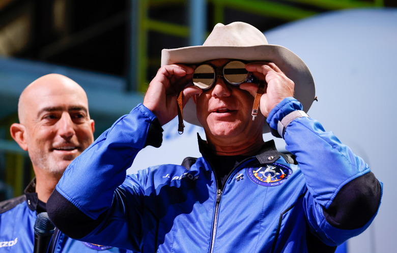 Billionaire American businessman Jeff Bezos wears goggles owned by Amelia Earhart which he carried into space at a post-launch press conference after he flew on Blue Origin's inaugural flight to the edge of space, in the nearby town of Van Horn, Texas, U.S., July 20, 2021. Bezos' brother Mark is on the left. REUTERS/Joe Skipper