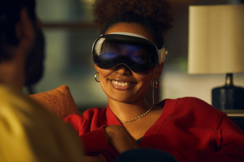 A person smiles while wearing the Apple Vision Pro headset.
