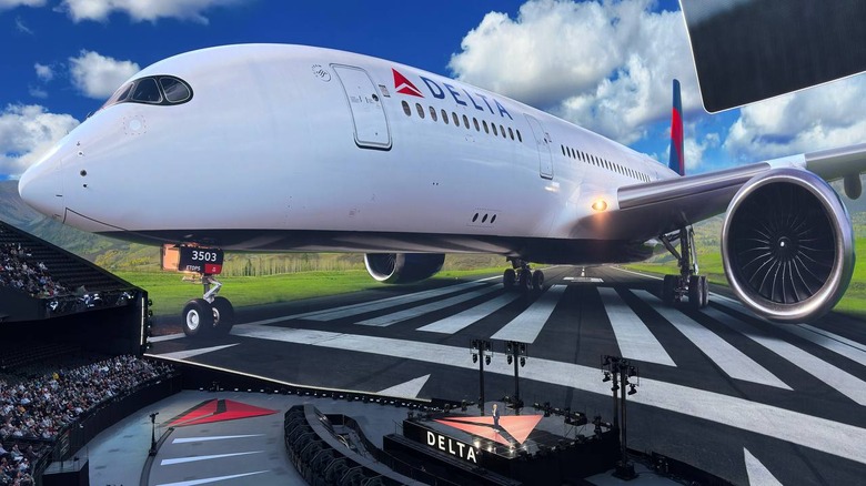 A large Delta airplane is the background of an event space with a relatively small stage in the middle and the word Delta emblazoned on it.