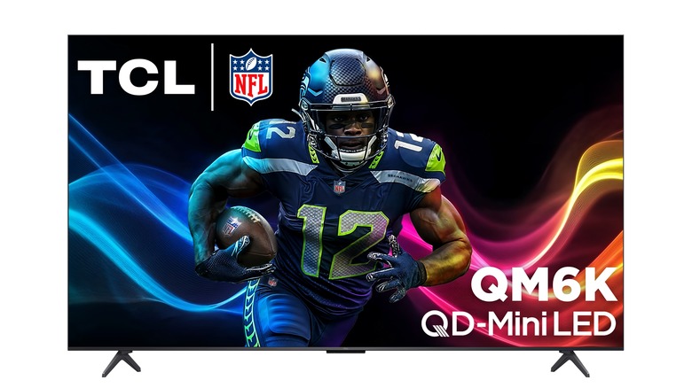 A thin TCL QM6K flatscreen TV on thin black legs.