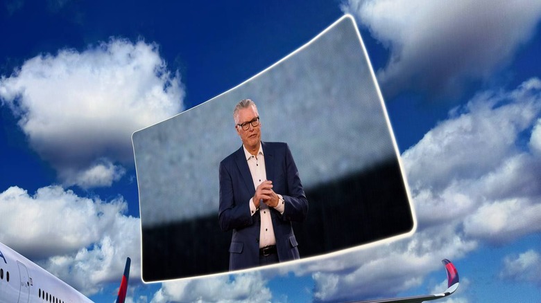 A floating window on a blue sky background, featuring Delta CEO Ed Bastian on a stage addressing an audience.