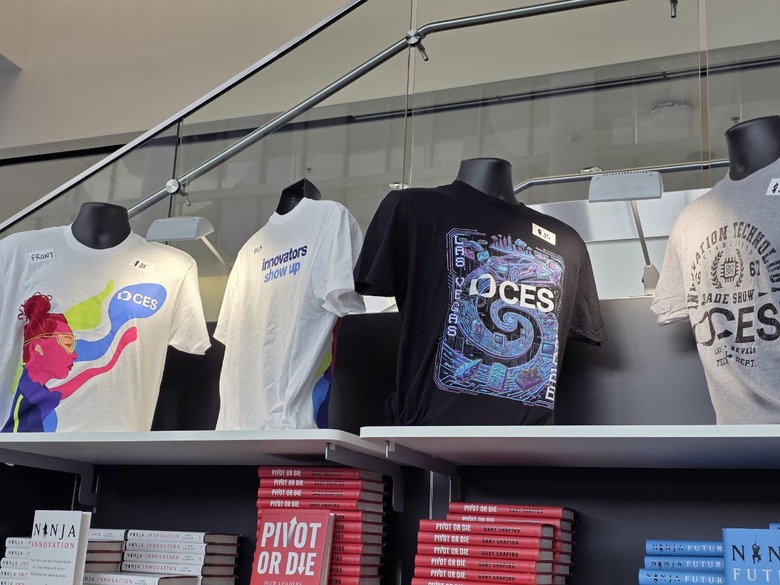 Four CES tshirts placed on half mannequins on a shelf.
