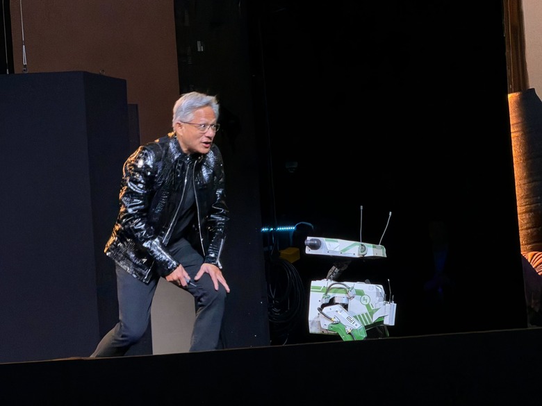 NVIDIA CEO Jensen Huang on bent knee in front of a robot on stage at CES 2026.