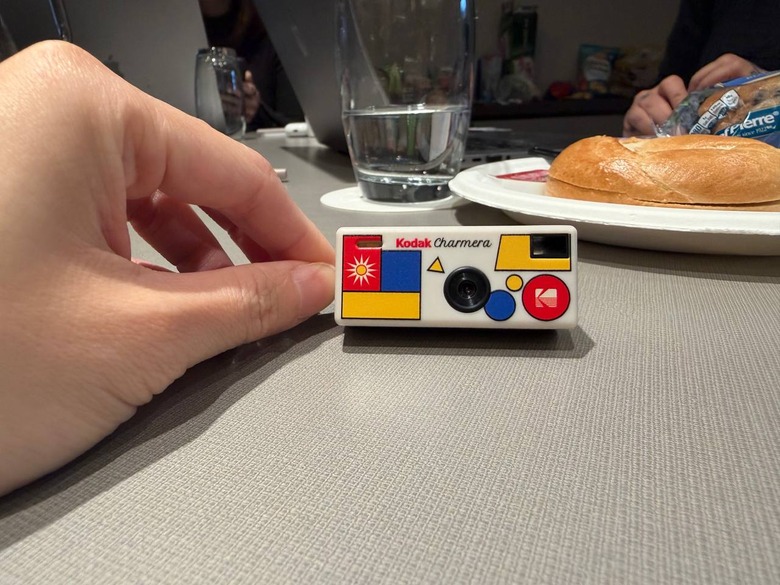A tiny Kodak camera in front of a plate with a bagel on it.