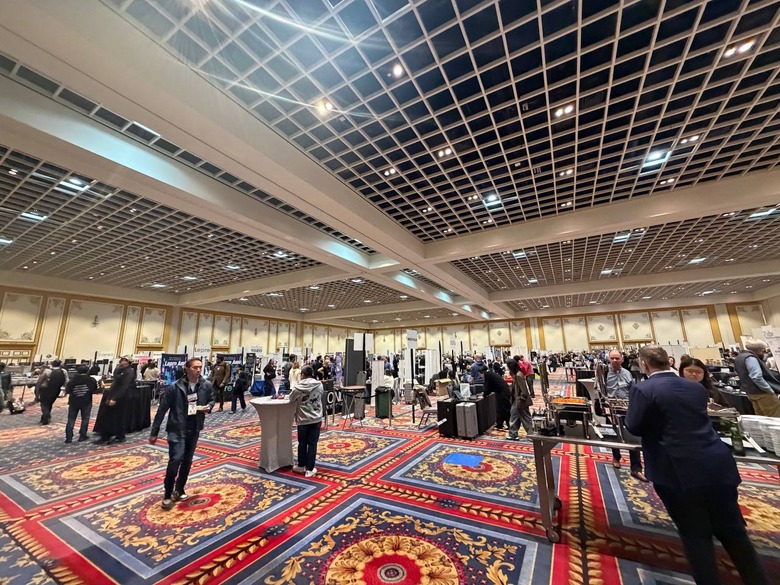 A wide-angle scene of a ballroom with tables and booths scattered all around