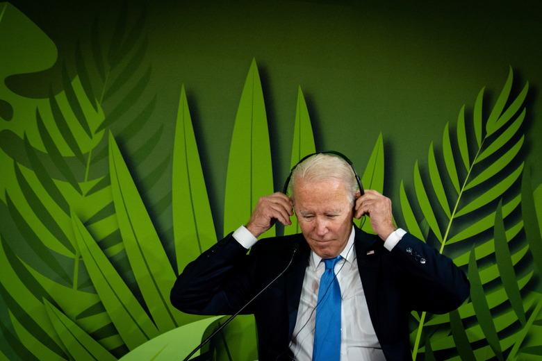 U.S. President Joe Biden puts on headphones to listen to speeches during 