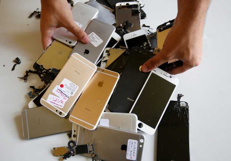 Worker checks Apple Iphones as he refurbishes cell phones at a workshop of the Oxflo company, specialised in refurbishment of broken European smartphones which will be resold back and provided with a warranty as part of an eco-responsible approach, in Lusignac, France, June 20, 2019. REUTERS/ Regis Duvignau