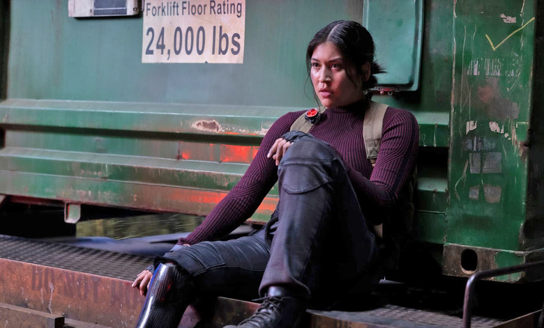 A young woman sits with one foot resting on a ledge in new Marvel series Echo.  