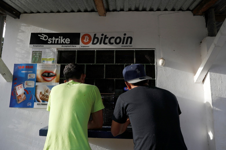 Men buy snacks at a store where bitcoins are accepted at El Zonte Beach in Chiltiupan, El Salvador June 16, 2021. REUTERS/Jose Cabezas