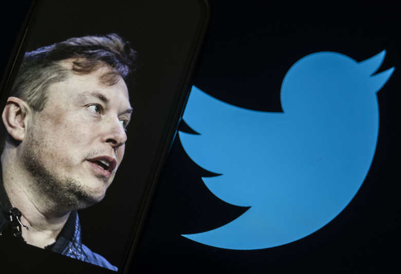ANKARA, TURKIYE - JULY 24: In this photo illustration, Elon Musk's photo is displayed on a phone screen in front of a computer screen displaying the former logo of 'Twitter' in Ankara, Turkiye on July 24, 2023. (Photo by Emin Sansar/Anadolu Agency via Getty Images)