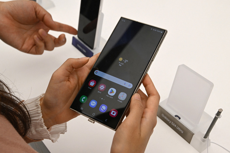 This picture taken on January 15, 2024 shows a woman looking at a Samsung Galaxy S24 Ultra smartphone displayed during a media preview event at a Samsung store in Seoul. (Photo by Jung Yeon-je / AFP) (Photo by JUNG YEON-JE/AFP via Getty Images)