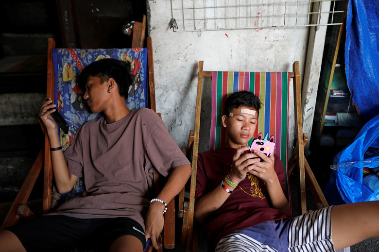 Youths use smartphones at Quiapo in Manila, Philippines, January 10, 2020. REUTERS/Willy Kurniawan