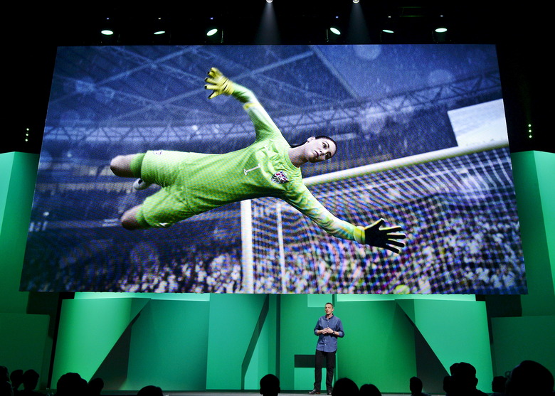 United State national soccer team's goalkeeper Hope Solo's image is shown on the screen as David Rutter, vice president and general manager of EA Sports FIFA, introduces the video game 
