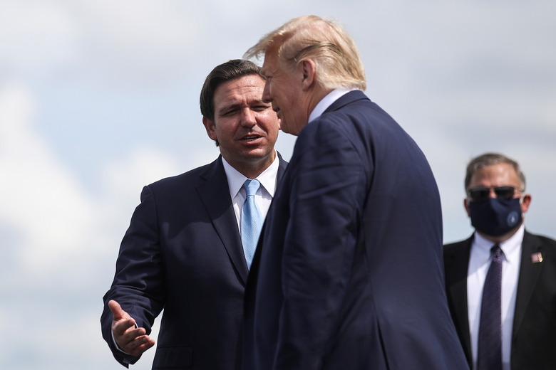 U.S. President Donald Trump is greeted by Florida Governor Ron Desantis as he arrives at Southwest Florida International Airport ahead of a campaign stop in Fort Myers, Florida, U.S., October 16, 2020. REUTERS/Carlos Barria