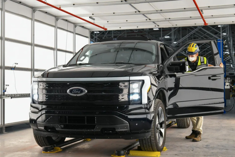 A factory worker looking inside of a Ford EV truck.