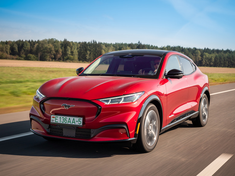 Minsk, Belarus - September 10, 2021: All-electric bright red Ford Mustang Mach-E drives on a highway during a sunny day.