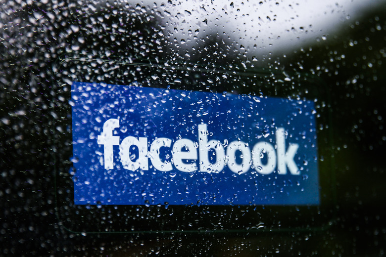 Facebook logo displayed on a phone screen is seen through raindrops on the window in this illustration photo taken in Krakow, Poland on July 17, 2021.  (Photo Ilustration by Jakub Porzycki/NurPhoto via Getty Images)