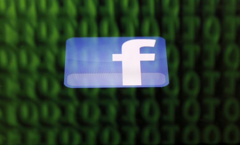 A Facebook logo on an Ipad is reflected among source code on the LCD screen of a computer, in this photo illustration taken in Sarajevo June 18, 2014.  Ireland's High Court on Wednesday asked the European Court of Justice (ECJ) to review a European Union-U.S. data protection agreement in light of allegations that Facebook shared data from EU users with the U.S. National Security Agency.   REUTERS/Dado Ruvic  (BOSNIA AND HERZEGOVINA - Tags: CRIME LAW BUSINESS POLITICS)