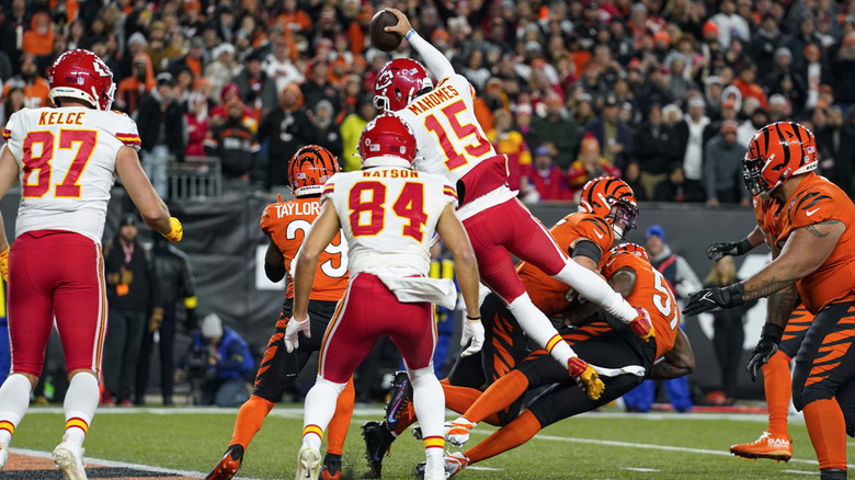 Image from an NFL game of Patrick Mahomes leaping over tacklers.