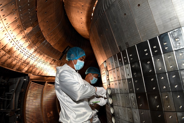 Staff members perform an upgrade to the experimental advanced superconducting tokamak EAST at the Hefei Institutes of Physical Science under the Chinese Academy of Sciences CAS on April 28, 2021. Chinese scientists have set a new world record of achieving a plasma temperature of 120 million degrees Celsius for a period of 101 seconds in the latest experiment on Friday, a key step toward the test running of a fusion reactor.     The experiment at the experimental advanced superconducting tokamak EAST, or the 