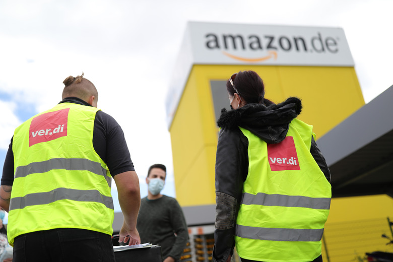 KOBERN-GONDORF, GERMANY - JUNE 29: Striking Amazon employees stand outside an Amazon warehouse during the coronavirus pandemic on June 29, 2020 in Kobern-Gondorf near Koblenz, Germany. The Verdi labor union has called for strikes at six Amazon warehouse across Germany in order to put pressure on the company over an ongoing disagreement over pay as well as improving workplace conditions to help prevent outbreaks of the coronavirus. Approximately 40 Amazon employees tested positive recently for Covid-19 infection at an Amazon warehouse in Bad Hersfeld. (Photo by Andreas Rentz/Getty Images)