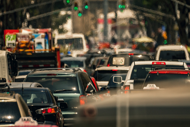 Heavy traffic and in the horizon the Metropolitan Cathedral in Mexico City, we can see cars, police trying to fix the traffic some street lights and far on the horizon, we can see the zocalo flag and the metropolitan cathedral. ​