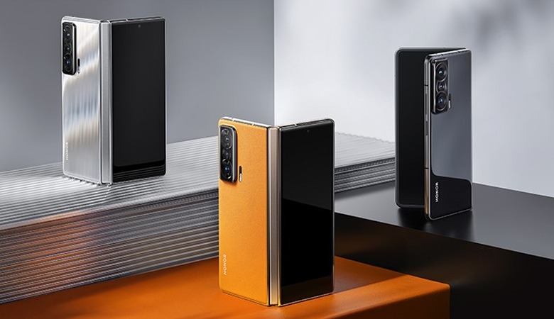 Honor's Magic V foldable smartphone in silver, orange and black variants.
