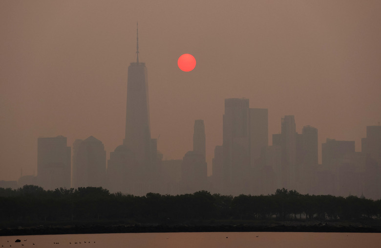 JERSEY CITY, NJ - JUNE 7: Smoke continues to shroud the sun as it rises behind the skyline of lower Manhattan and One World Trade Center in New York City on June 7, 2023, as seen from Jersey City, New Jersey.  (Photo by Gary Hershorn/Getty Images)