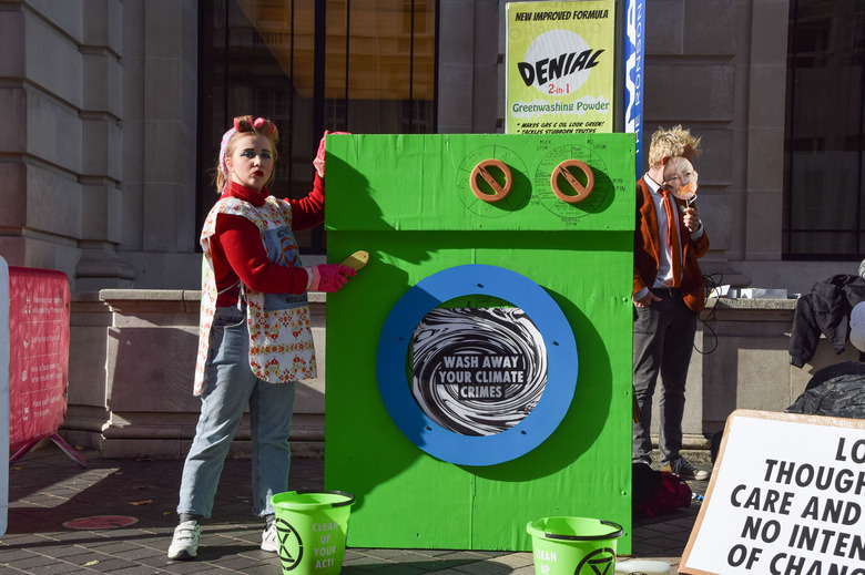 LONDON, UNITED KINGDOM - 2021/10/24: An activist dressed as a 'scrubber' cleans the 'greenwashing machine' during the protest outside the Science Museum. 
Extinction Rebellion activists gathered outside the museum in South Kensington in protest against the museum's 'greenwash' sponsorship by fossil fuel companies including Shell and coal giants Adani. (Photo by Vuk Valcic/SOPA Images/LightRocket via Getty Images)