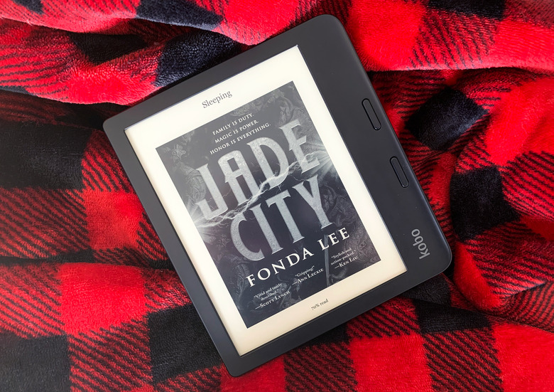 The Kobo Libra 2 e-reader sitting on a black and red checkered blanket.