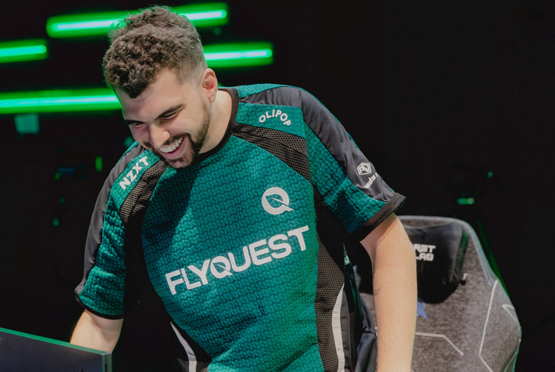A person wearing a FlyQuest shirt smiling.