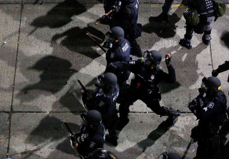 A Seattle Police officer throws a canister towards protesters during a protest against racial inequality in the aftermath of the death in Minneapolis police custody of George Floyd, near the Seattle Police department's East Precinct in Seattle, Washington, U.S. June 8, 2020. REUTERS/Lindsey Wasson