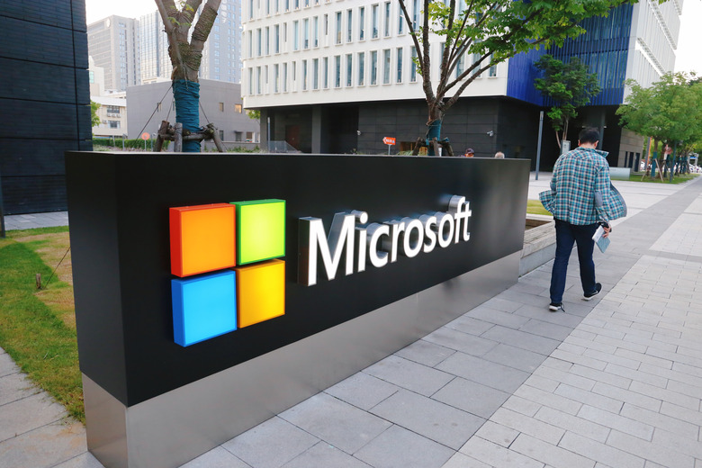 SHANGHAI, CHINA - JUNE 06: A man walks past a logo of Microsoft outside an office building at Shanghai Caohejing Hi-Tech Park on June 6, 2020 in Shanghai, China. (Photo by Chen Yuyu/VCG via Getty Images)
