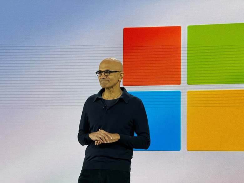 Microsoft CEO Satya Nadella on stage at the event, in front of a Microsoft logo.