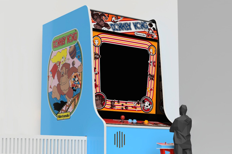 A large Donkey Kong arcade cabinet is shown with a black human figure standing at a smaller control panel in front of it.