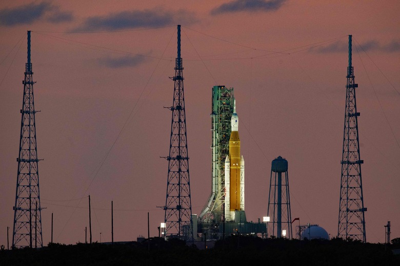 TOPSHOT - The Artemis I unmanned lunar rocket sits on launch pad 39B at NASA's Kennedy Space Center in Cape Canaveral, Florida, on September 25, 2022, just hours before it begins its rollback to the Vehicle Assembly Building (VAB). - NASA's Artemis 1 rocket -- waiting to blast off on a delayed mission to the Moon -- will be rolled back into its storage hangar Monday night, the space agency said, as Florida braces for Hurricane Ian. (Photo by Jim WATSON / AFP) (Photo by JIM WATSON/AFP via Getty Images)