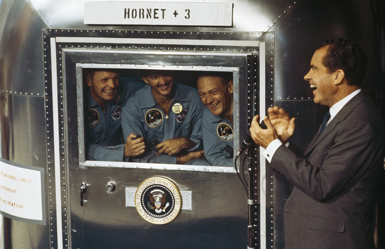 24th July 1969: From left to right, Neil Armstrong, Michael Collins and Edwin 'Buzz' Aldrin Jnr, the crew of the historic Apollo 11 moon landing mission are subjected to a period of quarantine upon their return to earth. Through the window of their Mobile Quarantine Facility, they hold a conversation with President Richard Nixon (1913 - 1994). (Photo by MPI/Getty Images)