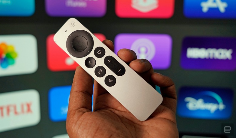 Apple TV remote with a selection of apps in the background