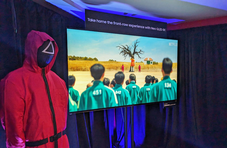 Samsung x Netflix Squid Game In-person pop-up showing a red-suited guard on the left of a TV showing the game.