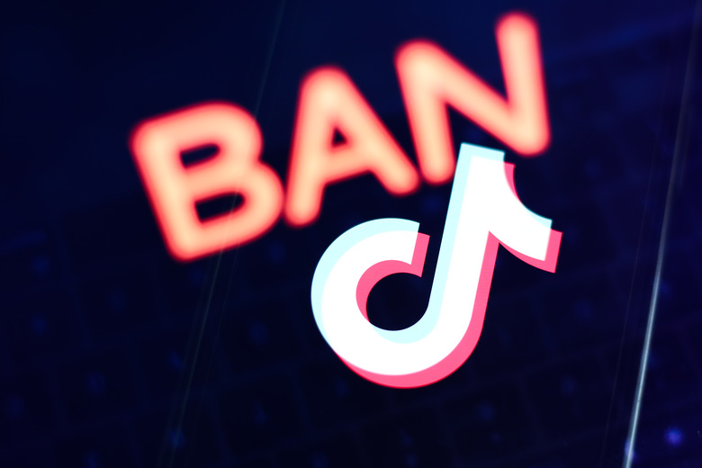 Ban sign displayed on a laptop screen and TikTok logo displayed on a phone screen are seen in this multiple exposure illustration photo taken in Krakow, Poland on March 27, 2023. (Photo by Jakub Porzycki/NurPhoto via Getty Images)