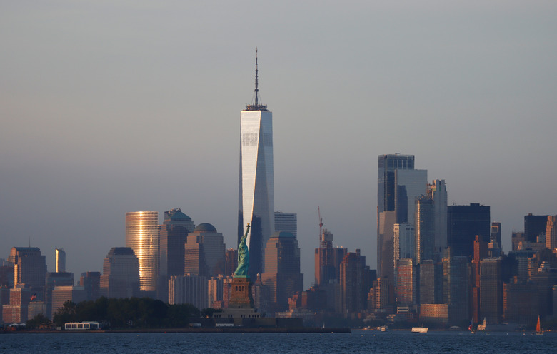 JERSEY CITY, NJ - JUNE 27: The sun sets on the skyline of lower Manhattan, One World Trade Center and the Statue of Liberty in New York City on June 27, 2021 as seen from Jersey City, New Jersey. (Photo by Gary Hershorn/Getty Images)