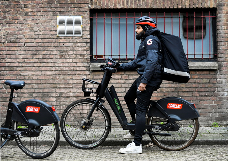 A courier of the fast grocery deliverer Gorillas sits on a bike as Amsterdam and Rotterdam have moved to ban new 