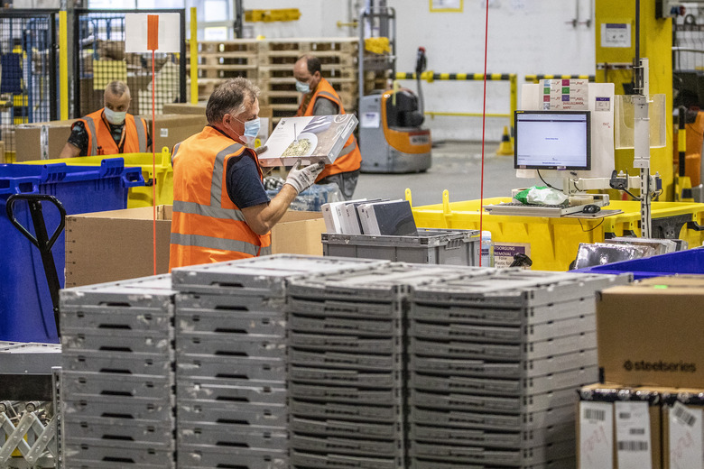 BRIESELANG, GERMANY - NOVEMBER 18: A worker packs items at an Amazon warehouse on November 18, 2021 in Brieselang, Germany. Many shoppers who fear gifts will be lacking due to the global supply chain disruption are buying their Christmas gifts early this year, both online and at brick and mortar retailers. (Photo by Maja Hitij/Getty Images)