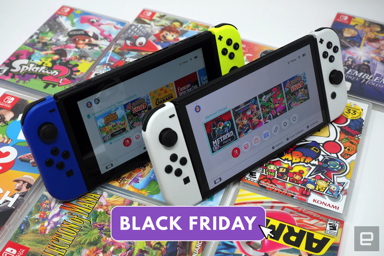 The Nintendo Switch OLED and base Nintendo Switch console sit on top of a collection of Nintendo Switch games.
