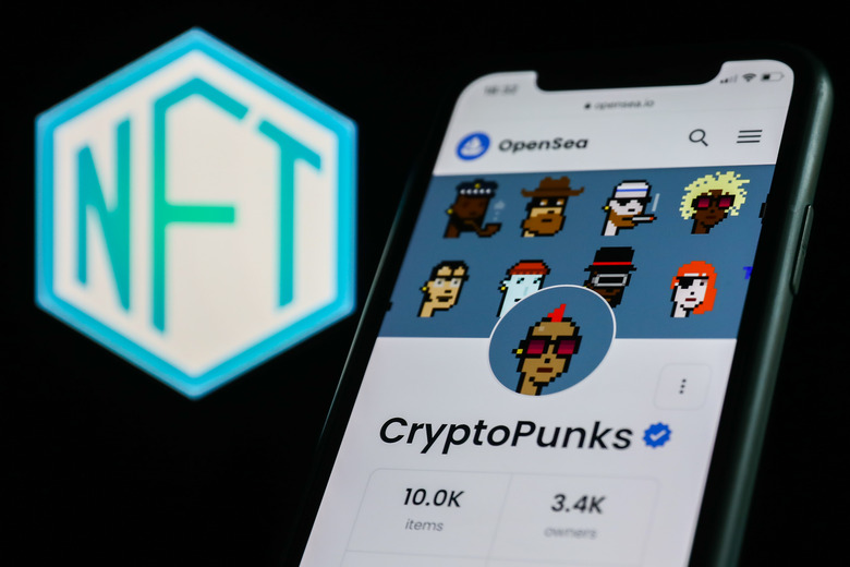 CryptoPunks collection in OpenSea displayed on a phone screen and NFT logo displayed on a screen are seen in this illustration photo taken in Krakow, Poland on April 19, 2022. (Photo by Jakub Porzycki/NurPhoto via Getty Images)